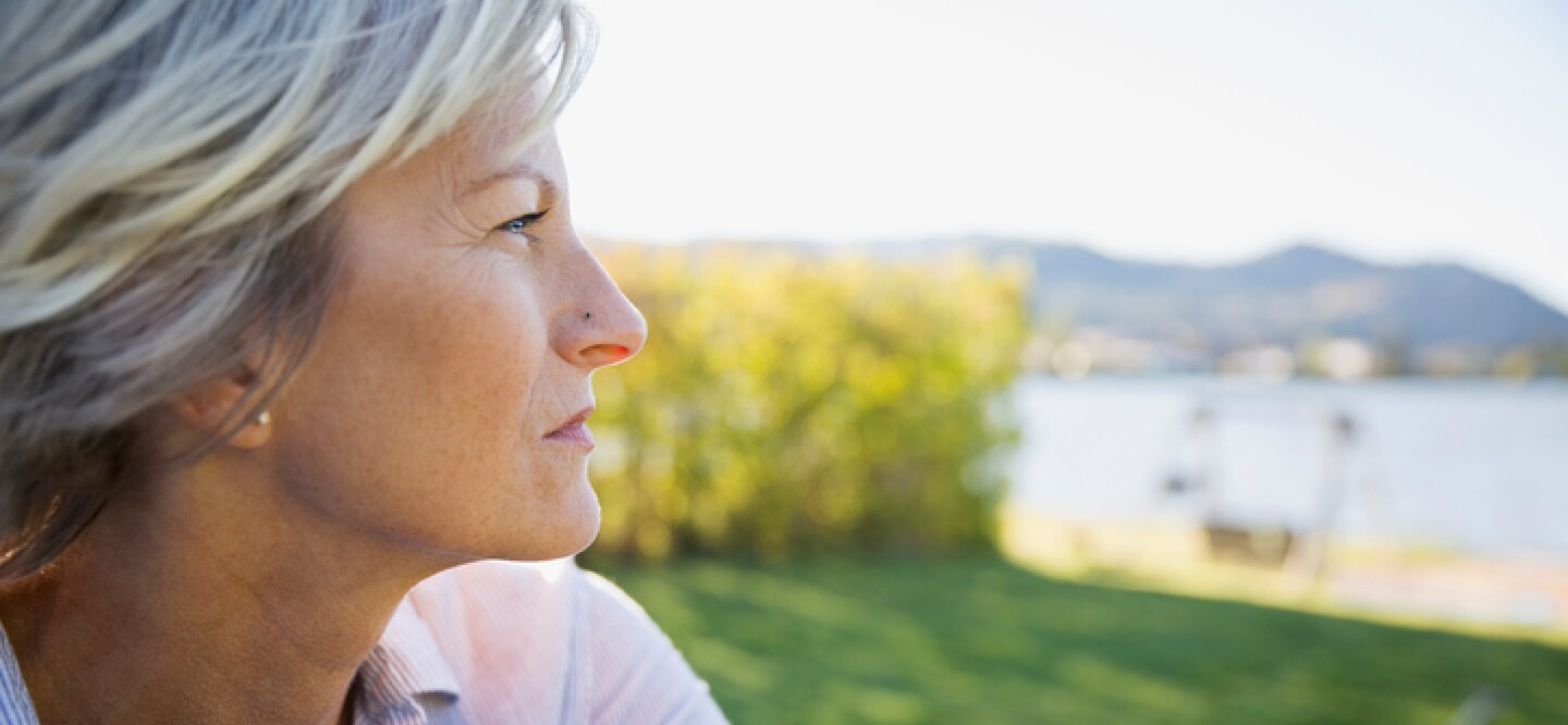 Close-up of a blonde woman looking at a lake 