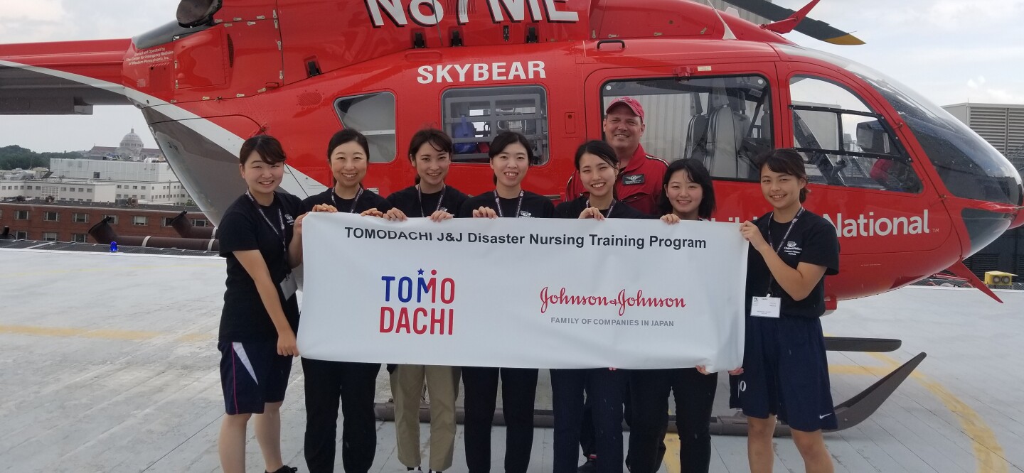 The Tomodachi J&J Disaster Nursing Training Program class of 2018 posing in front of the Children’s National Health System helicopter, which transports sick patients.