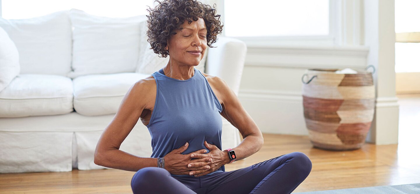 Silver-haired woman exercising and wearing her fitness watch.