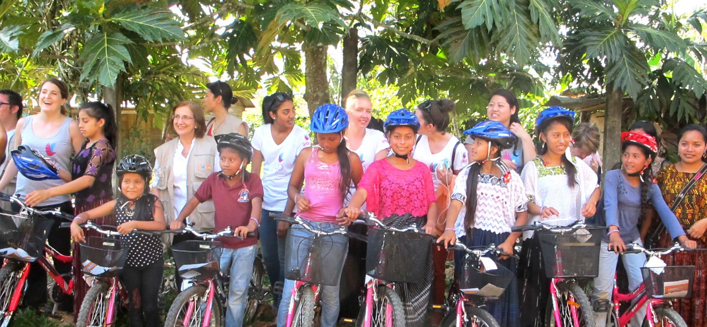 Young schoolgirls and members of Girl Up and UNFPA at a bike distribution in Guatemala
